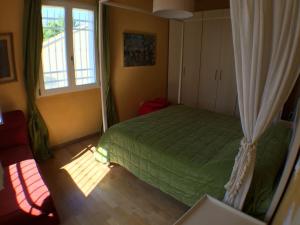 a bedroom with a green bed and a window at Casa Nina in Gabicce Mare