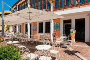 a patio with tables and chairs and an umbrella at Casa Nina in Gabicce Mare