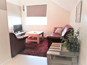 a living room with a couch and a table at Løvheim Gjestehus - Anneks in Sauland