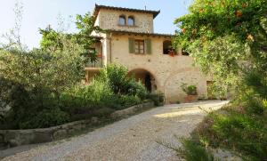 a stone house with a pathway in front of it at Podere Chiocciola in Poggibonsi