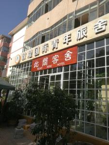 ein Gebäude mit Schildern an der Seite in der Unterkunft Right Here Hotel (Dunhuang International Youth Hostel) in Dunhuang