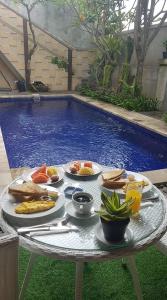 a tray of food on a table in front of a pool at Agus Villa in Sanur