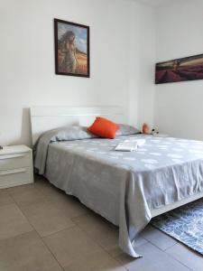 a bedroom with a bed and a painting on the wall at La Santera in Marina di Davoli
