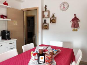 eine Küche mit einem Tisch mit einer roten Tischdecke in der Unterkunft La Santera in Marina di Davoli