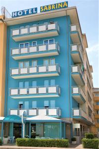 a hotel with a blue building with a hotel sigina at Hotel Sabrina in Sottomarina