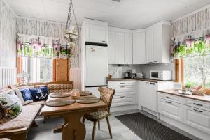 a kitchen with white cabinets and a table at Apartments Borg Ankkurikari in Pori