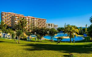 ein Resort mit einem Pool und Palmen in einem Park in der Unterkunft 102 Estudio en Jupiter Apartmentos - Piscina y Playa - Excelente Ubicación in Benalmádena