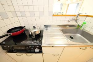 a kitchen with a stove with a pot on the stove at Near Nakajima park Close to Susukino Anbiennte 101 in Sapporo +36 photos