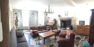 een woonkamer met lederen meubels en een open haard bij CasaLinda in Boutx