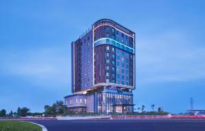 a tall building with a sign on the side of it at Novotel Karawang in Karawang