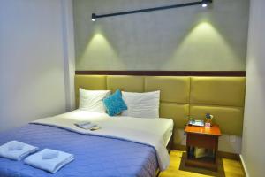 a bedroom with a bed with a blue and white bedspread at Giang Son Hotel 江山民宿胡志明市 in Ho Chi Minh City