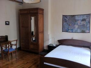 1 dormitorio con 1 cama y armario de madera en CasaLinda, en Boutx