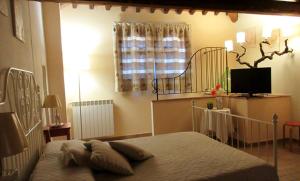 a bedroom with a bed and a television in it at Podere Chiocciola in Poggibonsi