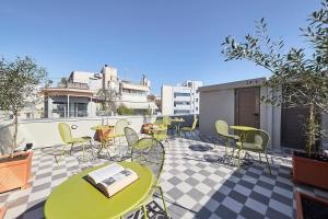 een patio met tafels en stoelen op een dak bij Explore Athens from an uber-central studio! in Athene