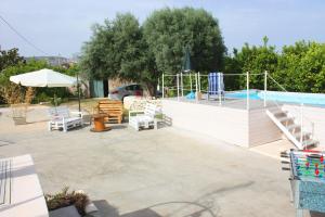 un patio con piscina junto a la piscina en I Colori degli Agrumi Holiday Home, en Floridia