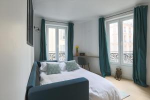 a bedroom with a bed with green curtains and a window at LE MATISSIA in Paris