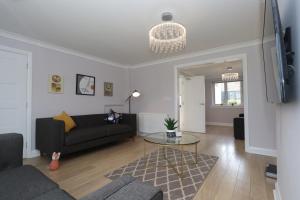 sala de estar con sofá y mesa en Dunfermline - Luxury 3 bedroom 2 bathroom detached house with garden, en Dunfermline