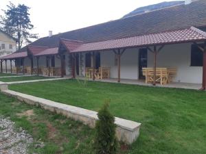 a pavilion with wooden tables and benches in a yard at Sobe Gmitrovic in Rtanj