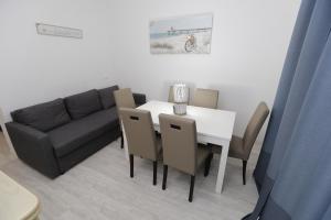a dining room with a table and a couch at Appartamenti Feel Good in Rimini