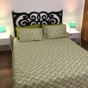 a bed with a black and white comforter and pillows at Charco Las Damas in Playa de San Juan