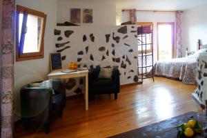 een woonkamer met een bed en een bureau met een stoel bij Casa Primavera in Genovés