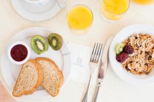 a table with two plates of food with toast and fruit at Hipotels Barrosa Park in Chiclana de la Frontera