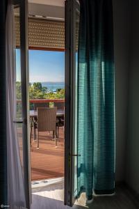 d'une porte coulissante en verre offrant une vue sur une terrasse. dans l'établissement Aranymandula apartmanok, à Balatonakali