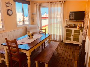 a dining room with a table and chairs and a television at Calella Skyline in Calella