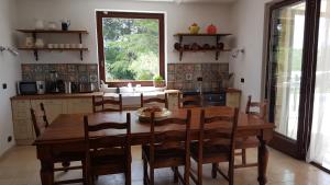 - une cuisine avec une table à manger en bois et des chaises dans l'établissement Trulli Parco Grande, à Putignano