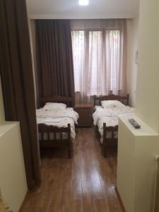 a small room with two beds and a window at Hotel VIVAS in Goris