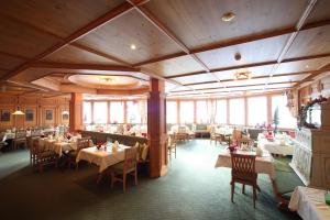 a dining room with tables and chairs and windows at Hotel Lamark in Hochfugen