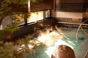 a swimming pool with a fountain in a building at Dormy Inn Premium Kyoto Ekimae Natural Hot Spring in Kyoto