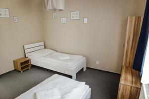 een kamer met 2 bedden en een nachtkastje bij Penzión Fonte in Radava