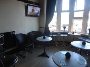 a room with tables and chairs and a tv at Alandene in Blackpool