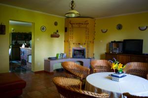 a dining room with a table and chairs and a kitchen at Dom gościnny LERKA Mazury jeziora lasy in Łąkorz