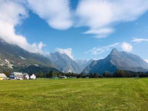 a field of grass with mountains in the background at Apartmaji Jana in Bovec