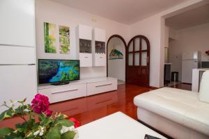 a living room with a white couch and a tv at Apartments Mila in Rovinj