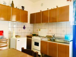 a kitchen with wooden cabinets and a white refrigerator at Apartmaji Jana in Bovec