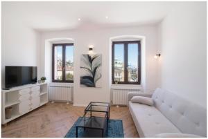 a white living room with a couch and a tv at Stylish - Centre Apartment Theatre View in Rijeka