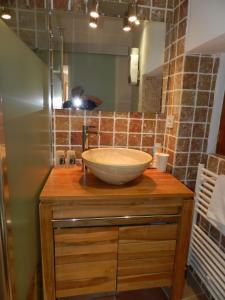 y baño con lavabo en un mostrador de madera. en Les Acanthes, en Lauris