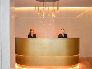 two women standing behind a counter in a lobby at Grand Hotel Terme Sirmione in Sirmione +37 photos
