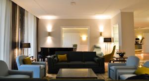 a living room with a couch and a piano at Grand Hotel Terme Sirmione in Sirmione