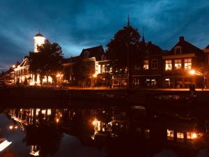 a city at night with buildings and a river at B&B Diepzicht in Dokkum
