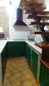 a kitchen with green cabinets and a stove at Vivienda rural fuente de los gusarapos in Burunchel