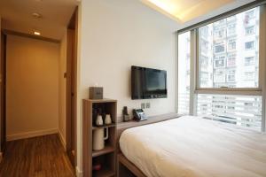 a bedroom with a large bed and a large window at Mia Casa Hotel in Hong Kong