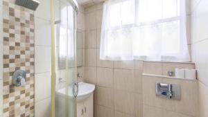 Un baño con inodoro y ducha con ventana. en LA Ballito, en Ballito 8 fotos más