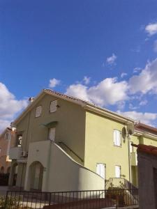 Apartman Igor في سيزيتشي: منزل اصفر امامه سياج