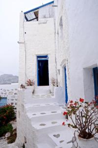 ein weißes Gebäude mit einer blauen Tür und einer Treppe in der Unterkunft Villa Clio Serifos in Serifos Chora