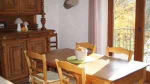 een houten eettafel met stoelen en een kom erop bij Gite Saboti in Dinant