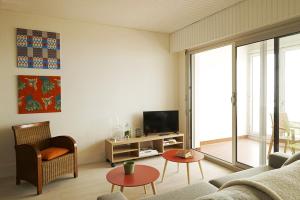 a living room with a couch and a tv at Un grand bol d’air avec vue sur mer à Saint Gilles in Saint-Gilles-Croix-de-Vie